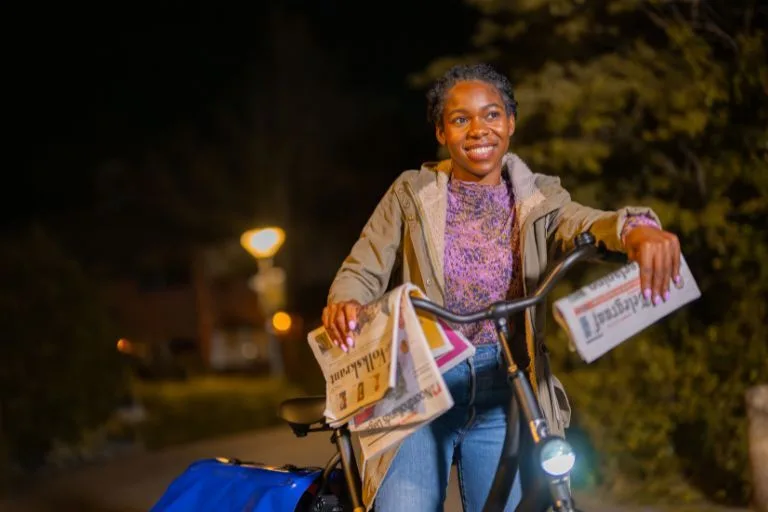 Content image Krantenbezorgster houdt krant vast