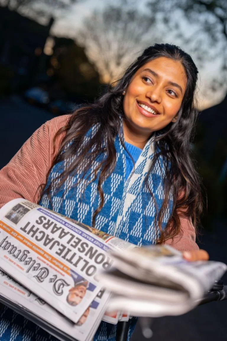 Content image Krantenbezorgster met een stapel kranten