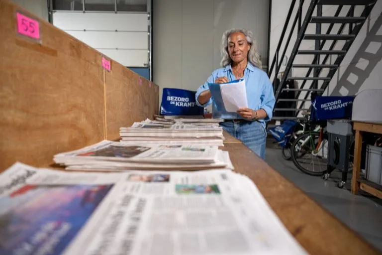 Content image depothouder sorteert de kranten