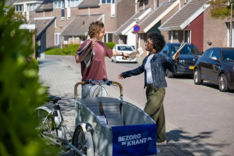Content image krantenbezorgers geven elkaar een knuffel